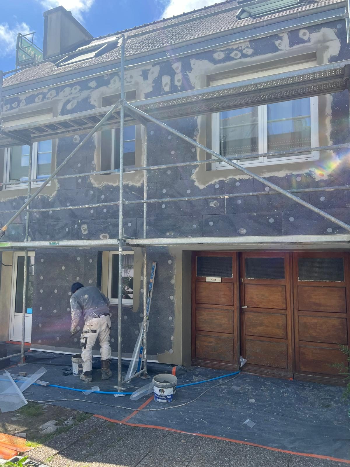 Artisan MADECO appliquant un enduit de façade
